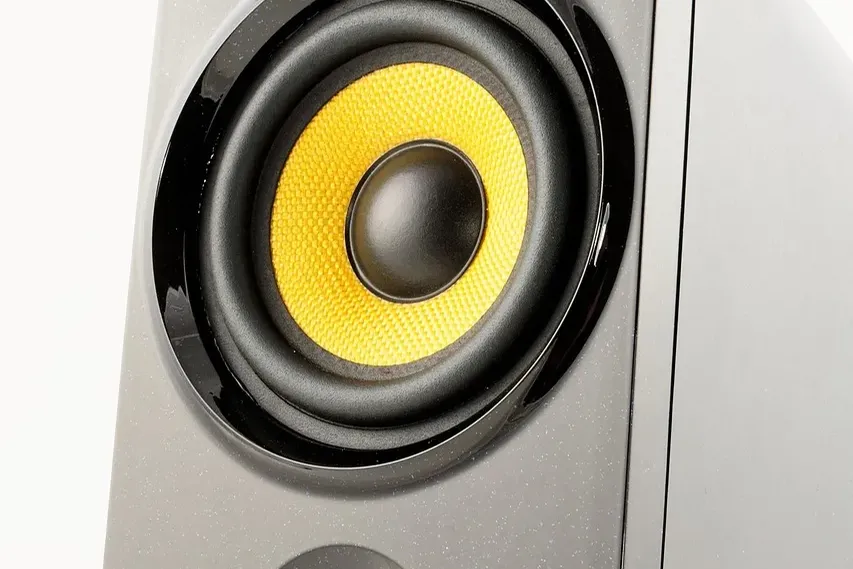 white and gray Google smart speaker and two black speakers